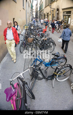 Stretta stradina laterale a Firenze affollate di persone pedoni shoppers & un incredibile groviglio di biciclette parcheggiate le moto Foto Stock