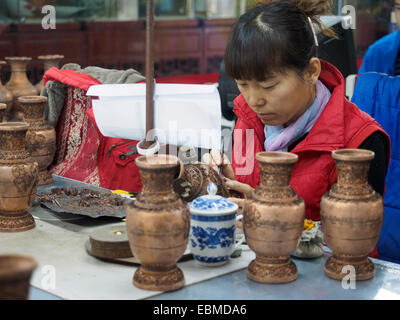 Donna che lavorano a un vaso di cloisonne fabbrica in Cina Foto Stock