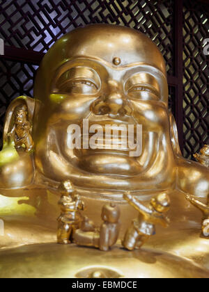 In prossimità della faccia di un Buddha Sorridente statua dorata Foto Stock