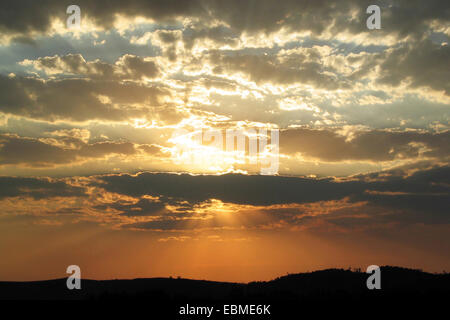 Tramonto Dorato con raggi che brilla attraverso le nuvole. Foto Stock