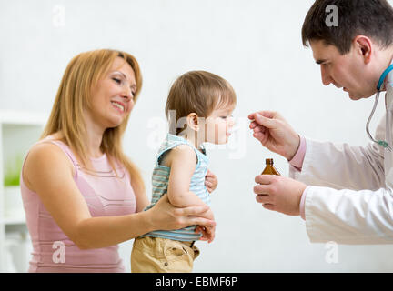Pediatra dando cucchiaio dose di medicina di bere allo sciroppo di baby Foto Stock