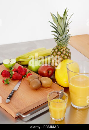 Vari tipi di frutta su un tagliere, succo d'arancia su un lato, Germania Foto Stock