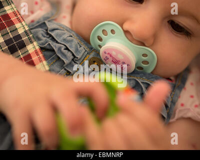 Bambina con il succhietto nella bocca stretta fino Foto Stock
