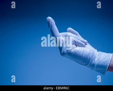 Mano in una lubrificato chirurgico guanto in lattice. Foto Stock