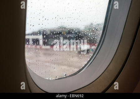 Guardando fuori di un Airbus A321 finestra coperto in gocce di pioggia a East Midlands Airport Foto Stock