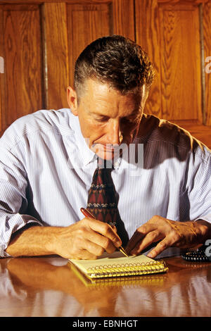 Imprenditore jotting idee su notepaper (50's) Foto Stock