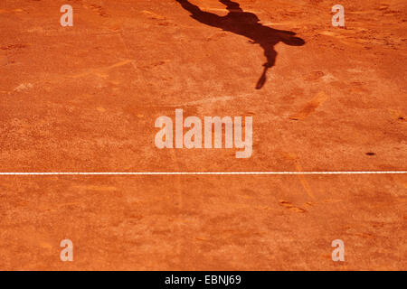 Ombra di un giocatore di tennis in servizio su una corte di argilla Foto Stock