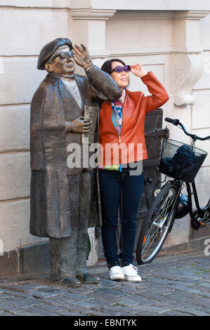 Un turista asiatica avente una foto insieme con Evert Taube la statua in bronzo, Järntorget, Gamla Stan, Stoccolma, Svezia Foto Stock