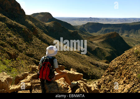 Femmina wanderer seduti sulle rocce di Naukluftberge e godendo della vista, Namibia, Namib Naukluft National Park Foto Stock