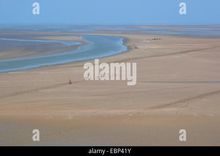 Sandy estuario a bassa marea con piane di marea escursionisti, Francia, Brittany Foto Stock