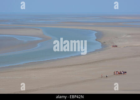 Sandy estuario a bassa marea con piane di marea escursionisti, Francia, Brittany Foto Stock