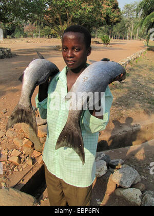 Giovane con due appena catturati pesci vicino al lago Tanganijka, Burundi, Rumonge, Bujumbura Foto Stock