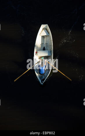 Vista aerea di un uomo che rema una barca a remi in vetroresina / skiff / dinghy , Finlandia Foto Stock