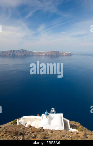 Imerovigli, Santorini, Egeo Meridionale, Grecia. Vista da Skaros Rock alla cappella della Panagia Theoskepasti e distante Thirasia. Foto Stock