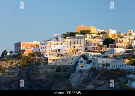 Firostefani, Santorini, Egeo Meridionale, Grecia. Cluster di clifftop edifici illuminati dalla RISING SUN. Foto Stock