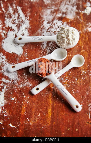 White misurini con cacao e la farina su una tavola di legno Foto Stock