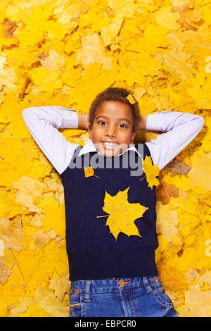 Bel ragazzo felice in autunno foglie di acero Foto Stock