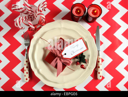 Luminose colorate Natale moderno bambini festa di famiglia tabella inserire le impostazioni in rosso e bianco tema su una striscia di chevron tabella. Foto Stock