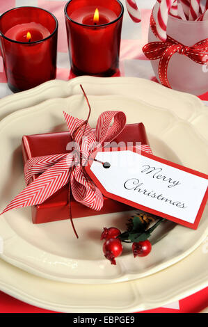 Luminose colorate Natale moderno bambini festa di famiglia tabella inserire le impostazioni in rosso e bianco tema su una striscia di chevron tabella. Foto Stock