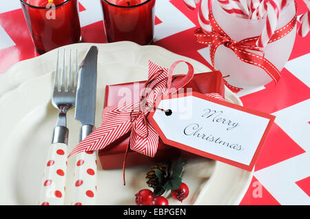 Luminose colorate Natale moderno bambini festa di famiglia tabella inserire le impostazioni in rosso e bianco tema su una striscia di chevron tabella. Foto Stock