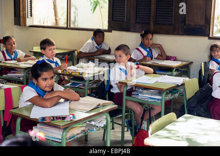 L'Avana, Cuba - 5 Maggio 2014: gruppo cubano di scolari di età elementari vestito in uniforme seduto a un mattone di Havan Foto Stock