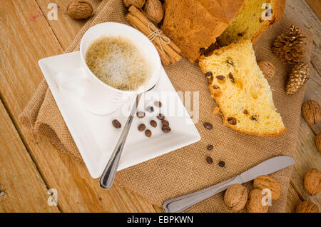 Panettoni artigianali con una tazza di cappuccino e alcuni ingredienti Foto Stock