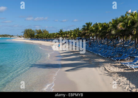 Turista su una spiaggia di sabbia bianca, palme e vuoto di sedie a sdraio, Grand Turk, Turks e Caicos, West Indies, dei Caraibi Foto Stock