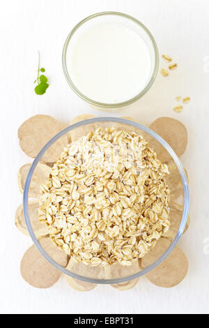 Oat-fiocchi in recipiente di vetro e latte fresco Foto Stock