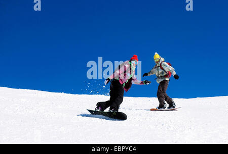 Due snowboarder sulla via, Francia, Savoie Foto Stock