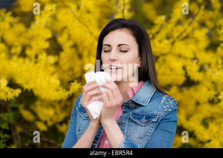 Starnuti giovane donna con rinite allergica Foto Stock