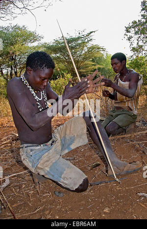 Hadzabe Boscimani che compongono il fuoco con un bastone, Tanzania Foto Stock