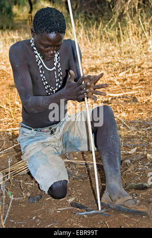 Hadzabe bushman che compongono il fuoco con un bastone, Tanzania Foto Stock