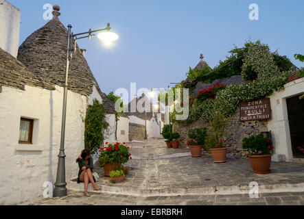 Street con Trulli Case al calar della sera, Alberobello, Puglia, Italia Foto Stock