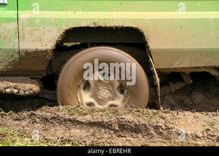 Ruota di filatura di un safari auto bloccata nel fango, Tanzania Serengeti National Park Foto Stock