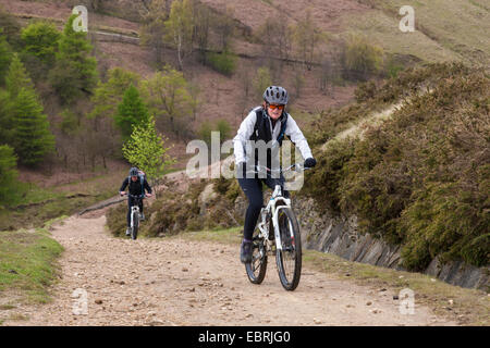 In bicicletta nel Parco Nazionale del Peak District. Due ciclisti su una salita di via sul lato nord di Jaggers Clough, Derbyshire, England, Regno Unito Foto Stock