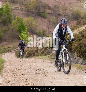 Mountain bike nel Regno Unito. I ciclisti escursioni in bicicletta su un percorso in salita sul lato nord di Jaggers Clough, Derbyshire, Peak District, England, Regno Unito Foto Stock