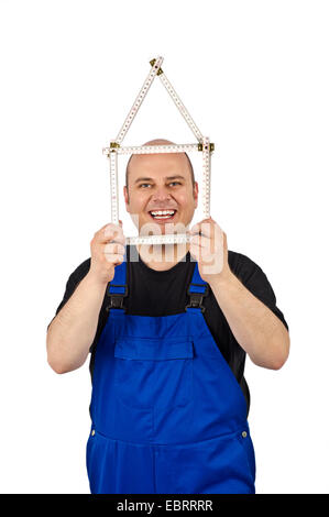 Artigiano che mostra una regola pieghevole nella forma di una casa Foto Stock