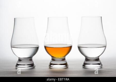 Tre retro-illuminato bicchieri di cristallo contenente chiare e ambra liquore. La vodka whiskey Bourbon, il brandy, ecc. Foto Stock