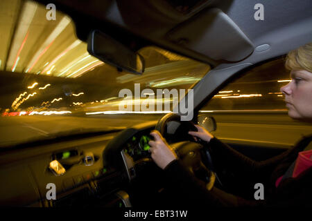 Donna guidare di notte in autostrada, Regno Unito Inghilterra Foto Stock