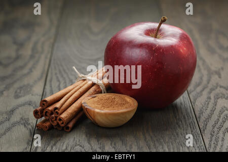 Ripe rosso mela e cannella, sul vecchio tavolo in legno di quercia Foto Stock