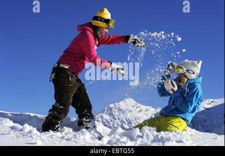 Due ragazze adolescenti avente una lotta di neve, Francia, Savoie Foto Stock