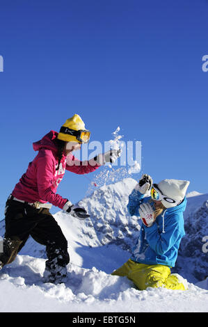 Due ragazze adolescenti avente una lotta di neve, Francia, Savoie Foto Stock