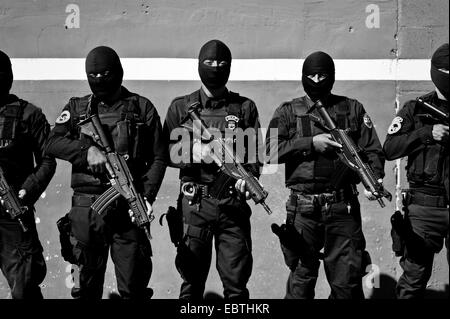 Salvadorean poliziotti, membri della specializzata anti-pista unità (Unidad Antipandillas), ricevere un ordine sulla base di polizia prima di lasciare per un funzionamento in San Salvador El Salvador, 19 dicembre 2013. Foto Stock