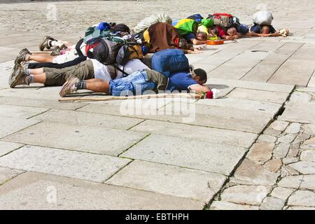 I pellegrini brasiliani giacente a terra e pregando davanti alla cattedrale il Praza do Obradoiro, Spagna Galizia, Coruña±a Santiago de Compostela Foto Stock