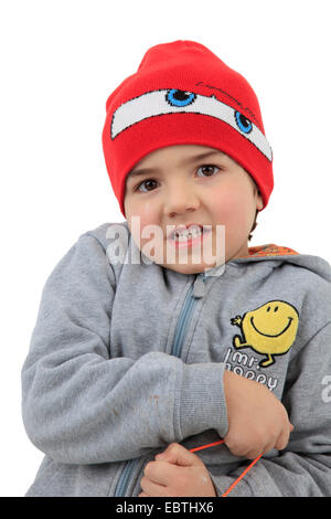 Piccolo ragazzo che indossa un cappellino e una felpa con cappuccio Foto Stock