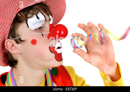 Clown che soffia in una carta streamer Foto Stock