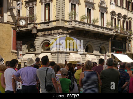 Un gruppo di tour in piedi in una piazza di Firenze, Italia Foto Stock