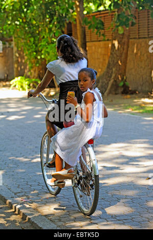 Due ragazze in bicicletta assieme su una bici, Seicelle Foto Stock