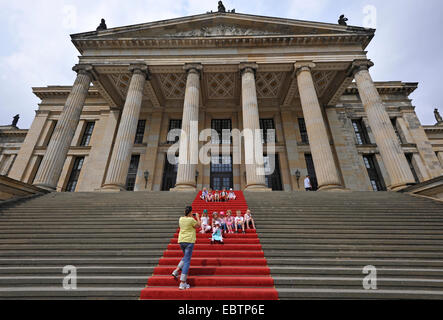 Donna di scattare una foto di bambini seduti sul tappeto rosso al Konzerthaus Berlin Situato sulla Gendarmenmarkt, Germania Berlino Foto Stock