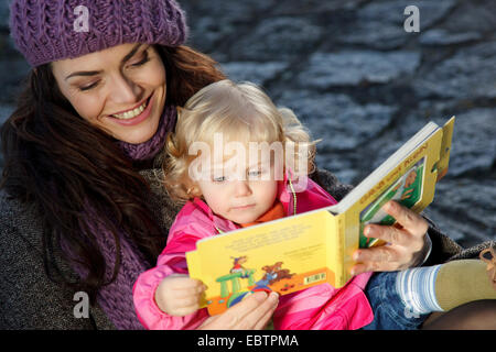 Giovane Donna con bambina la lettura di un libro Foto Stock